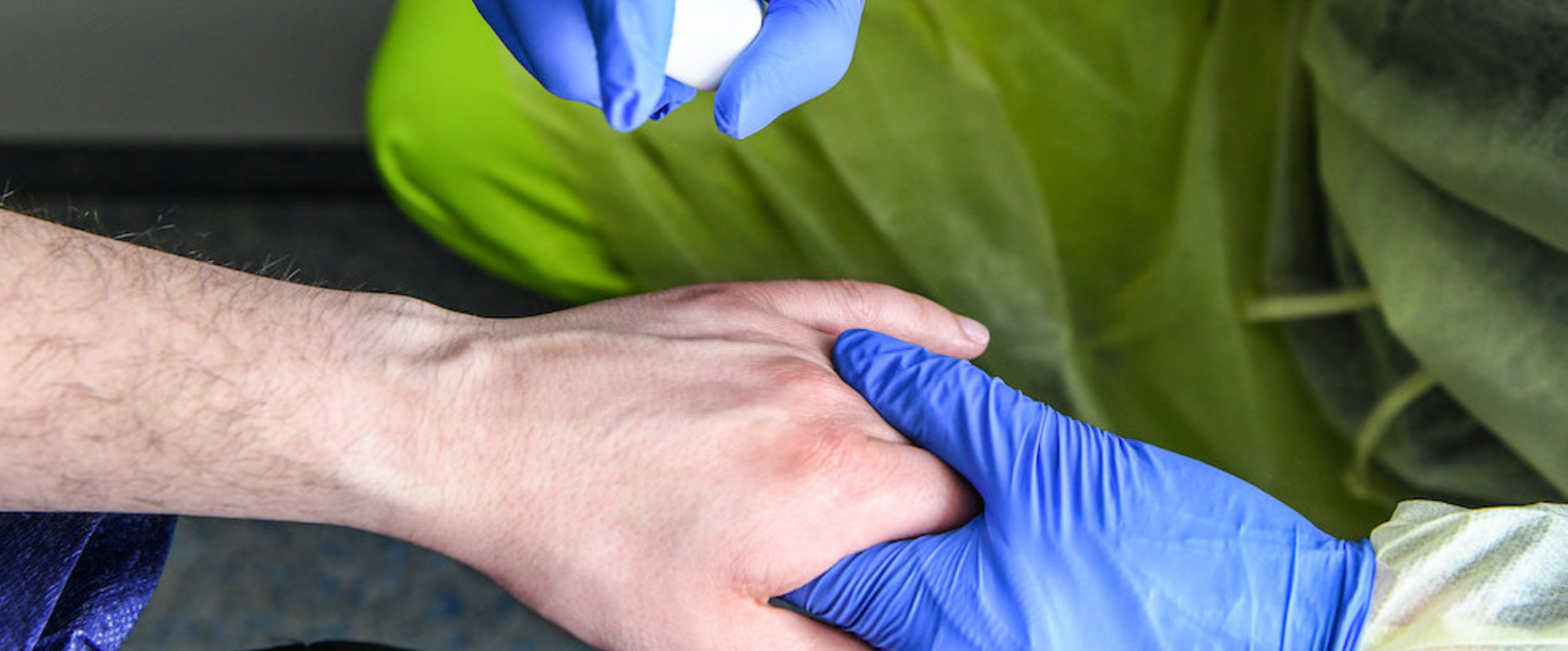 Ein Rettungssanitäter desinfiziert den Handrücken eines Notfallpatienten im Rettungswagen während einer Übung in Bonn am 17. April 2021.